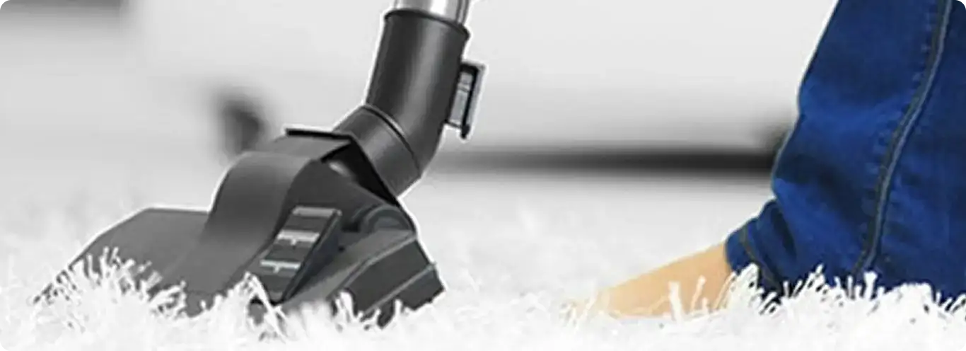 Close-up of a professional vacuuming a white carpet in Glen Allen.